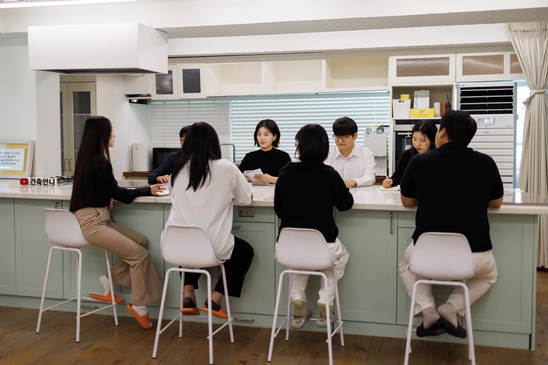 사무실 큰 탁자에 모여 앉은 직원들