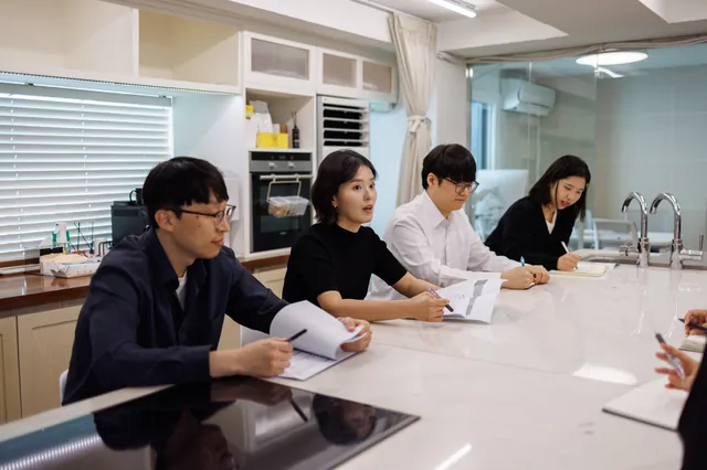 건창건축사사무소 직원들이 회의 탁자에 둘러앉은 모습